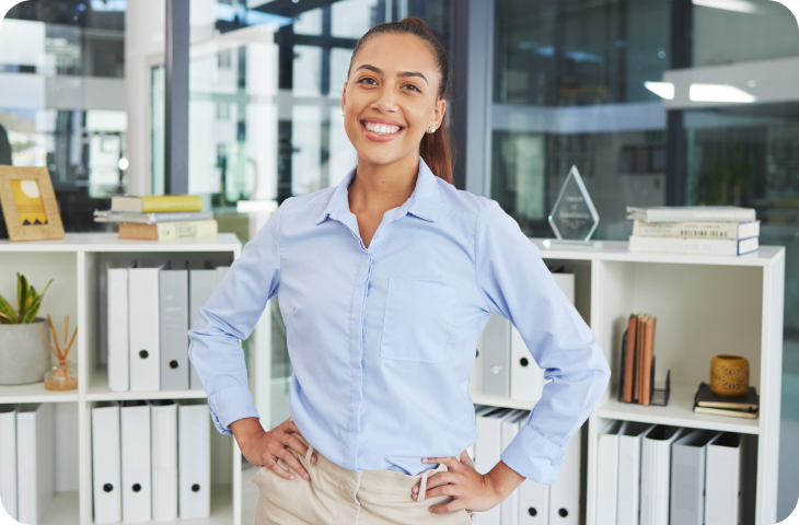 A female employee is smiling and standing in the office.