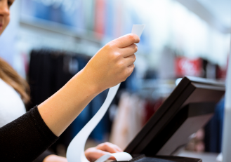 An employee holding a customized receipt generated by POS.