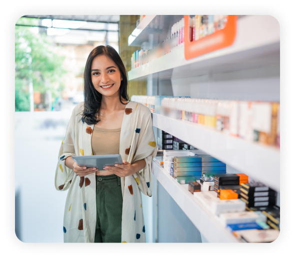 A female employee standing in a smoke shop is holding a tablet.