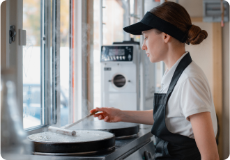 A female employee wearing a black hat is working at the restaurant.