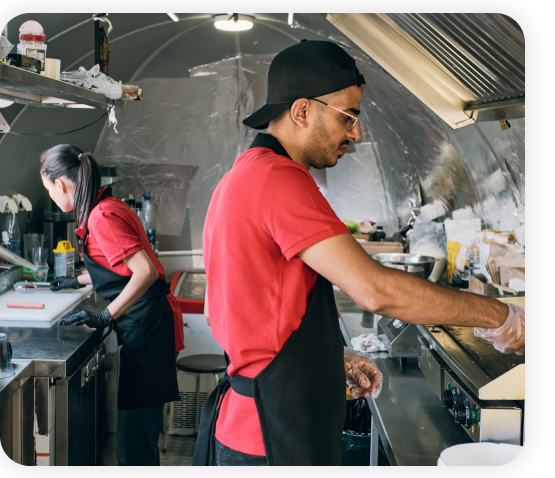 Two employees working in the fast-food kitchen.
