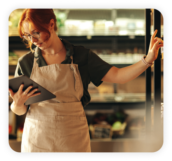 A female employee wearing an apron is using the tablet.