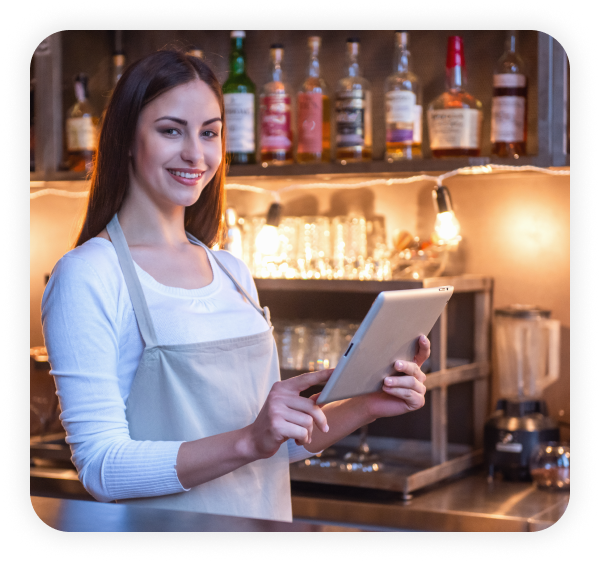 A happy female bartender is using the tablet.