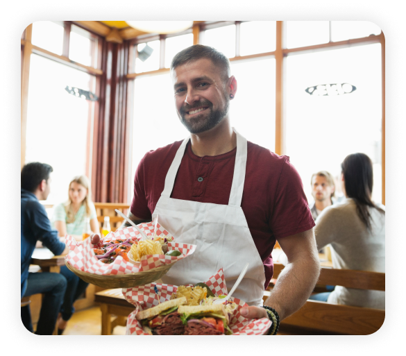 A waiter wearing an apron is holding a customer order.