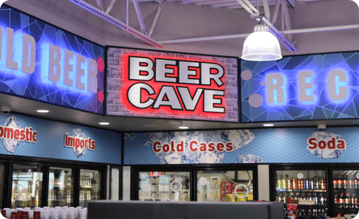 Time Mart convenience store interior featuring beverage coolers, product displays, and illuminated Beer Cave signage.
