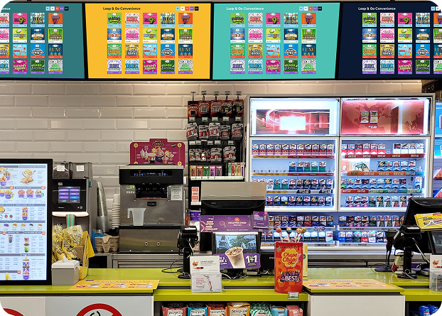 Convenience store checkout area featuring digital lottery displays, self-service kiosks, and lottery product merchandising.