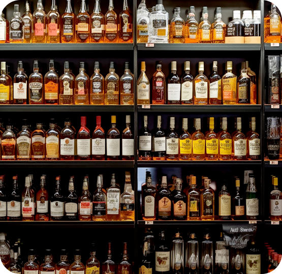 Liquor store shelving displaying a wide selection of spirits, whiskey, wine, and bottled beverage products.
